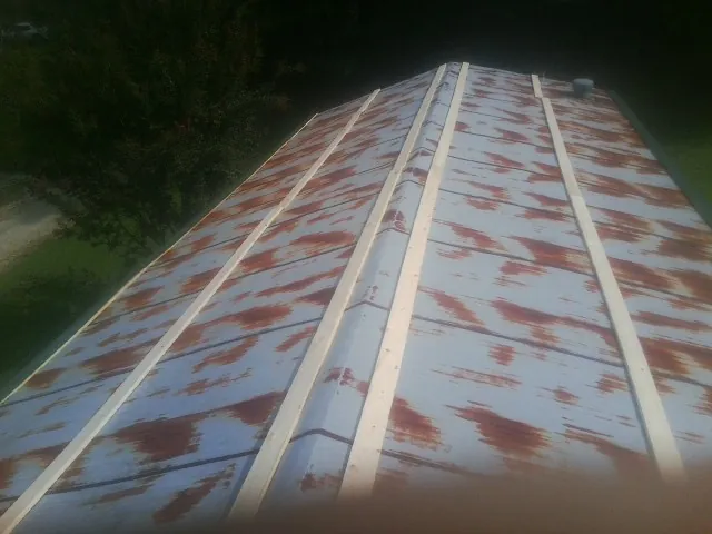 Rusted metal roof panels with new wood purlins before replacement — Storm Damage Roof Repair in Forest by Roofing Brothers